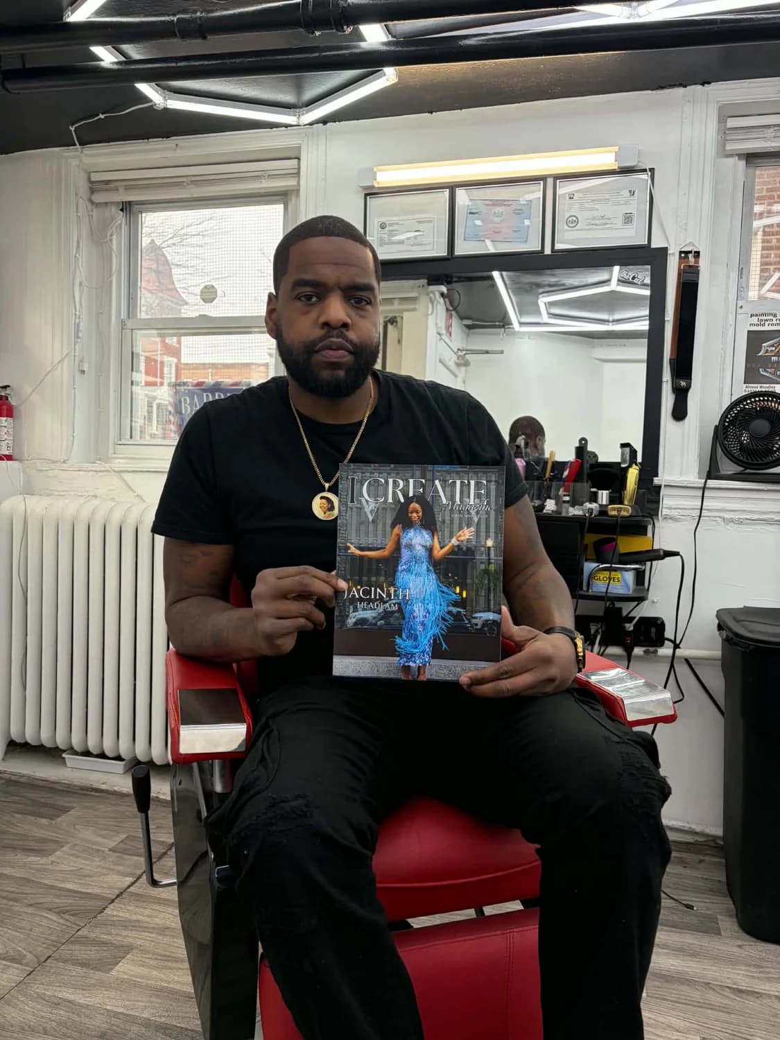 Community member holding an issue of I Create Magazine
